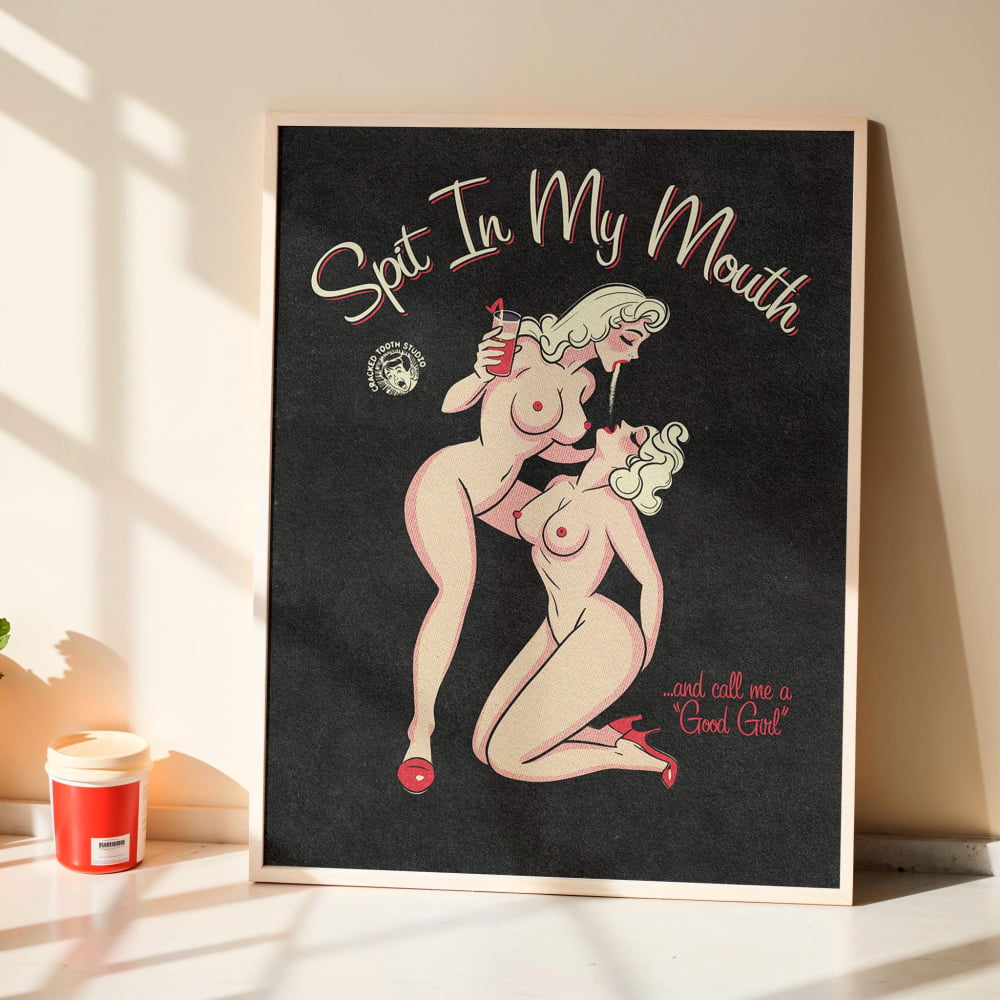 a framed illustration of two naked women embracing, with the text "Spit In My Mouth" and "and call me a Good Girl" written below the illustration.