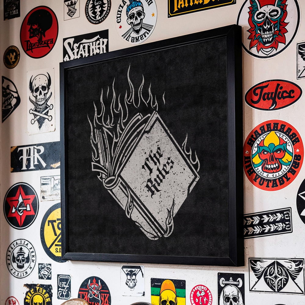 a wall adorned with a variety of stickers, patches, and graffiti, including a prominent black and white graphic of a book with flames on the cover.