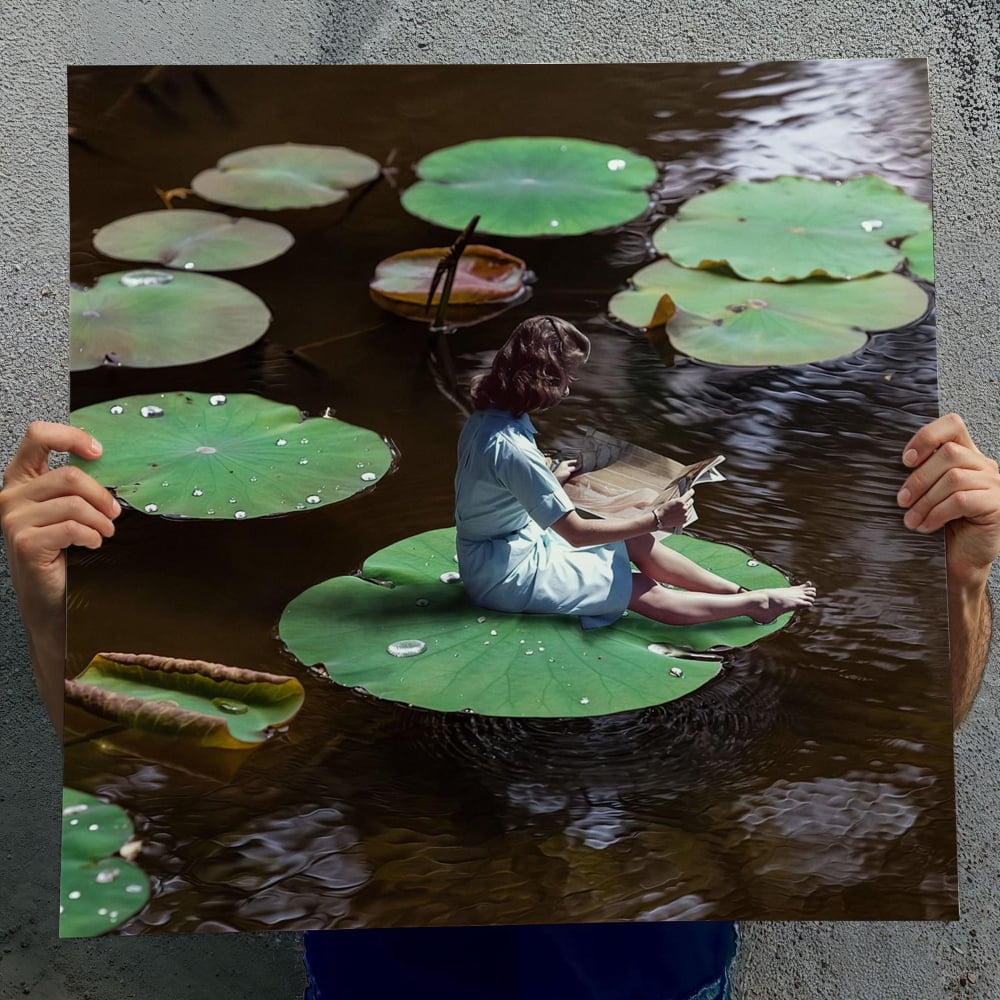 A person is sitting on a lily pad in a pond, reading a book.