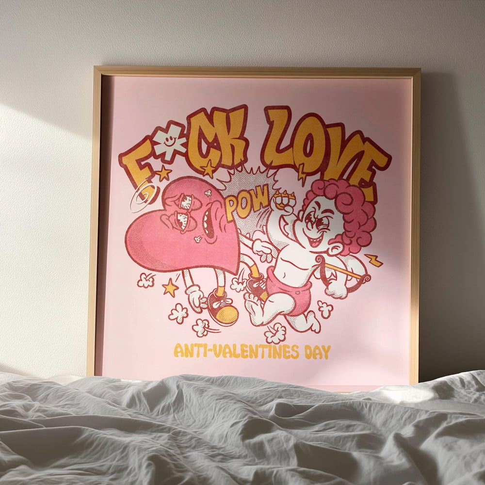 a framed poster with a cartoon-style illustration of a heart and a cupid character, along with the text "F*CK LOVE POW" and "ANTI-VALENTINES DAY".