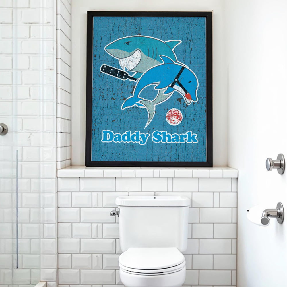 a bathroom with a framed poster of a blue shark and a dolphin, which is mounted above a white toilet.