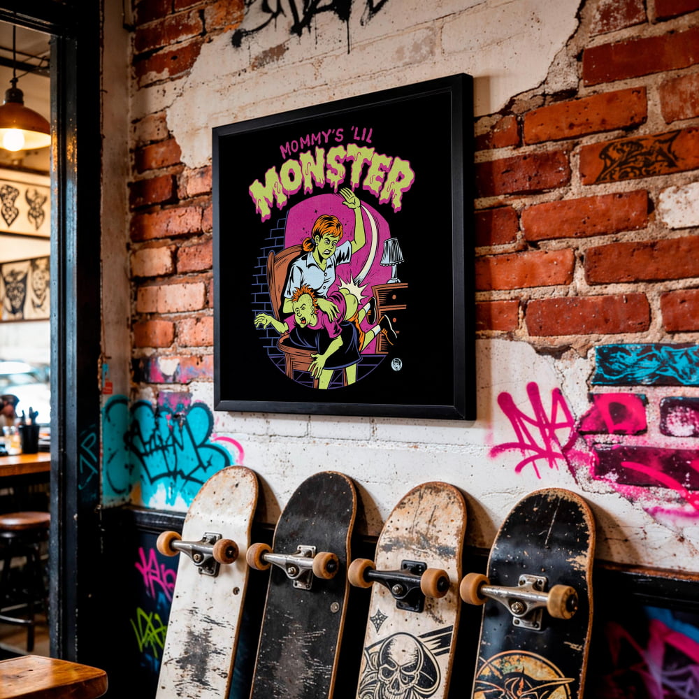 a wall with a framed poster of a cartoon monster, a row of skateboards leaning against the wall, and graffiti on the brick wall.