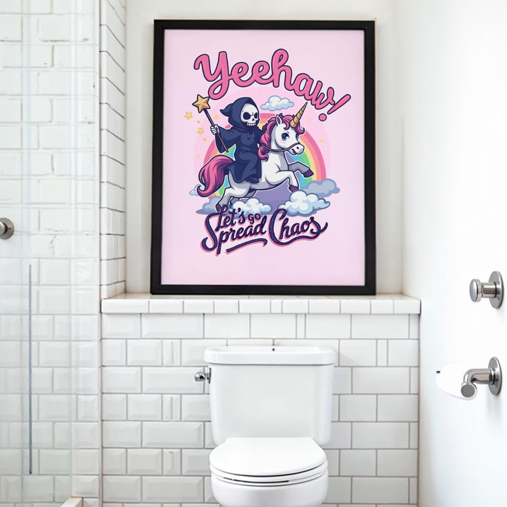 a bathroom with a toilet and a framed poster on the wall. The poster has a cartoon image of a person riding a unicorn and the text "Yeehaw! Let's spread chaos!"