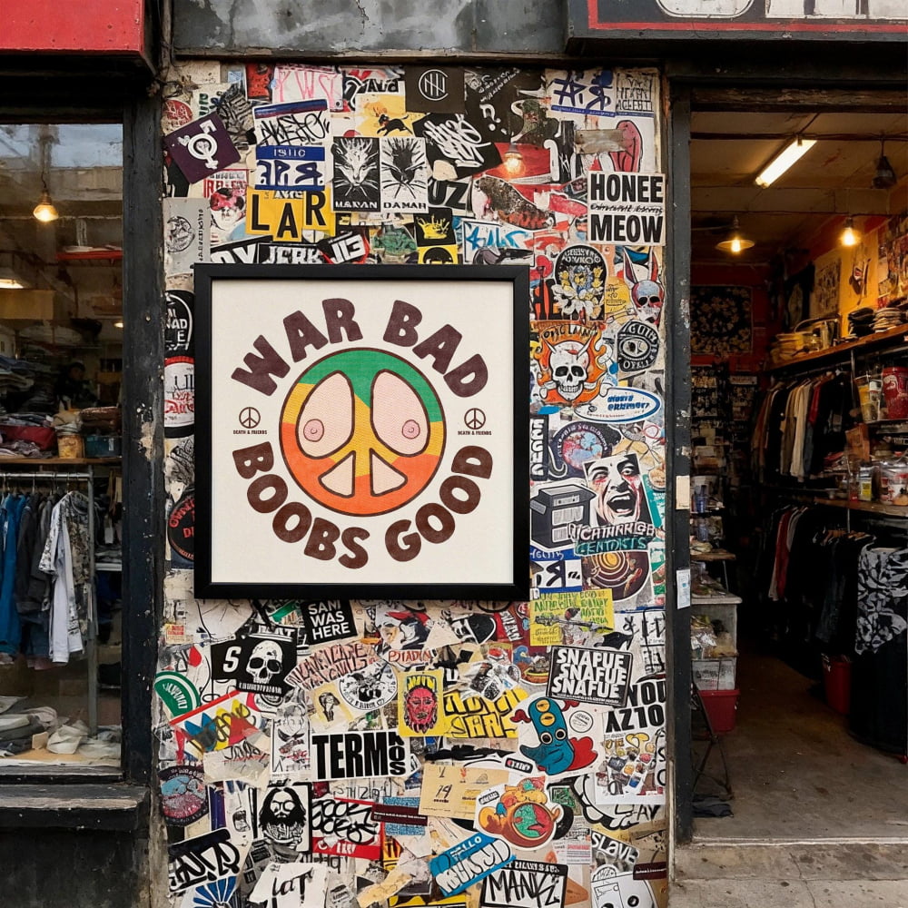 The image is a wall covered in a collage of various stickers, posters, and graffiti, including a prominent sign that reads "War Bad Boobs Good".