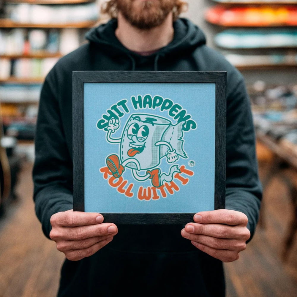 A man holding a framed picture with a cartoon character and text in a store.