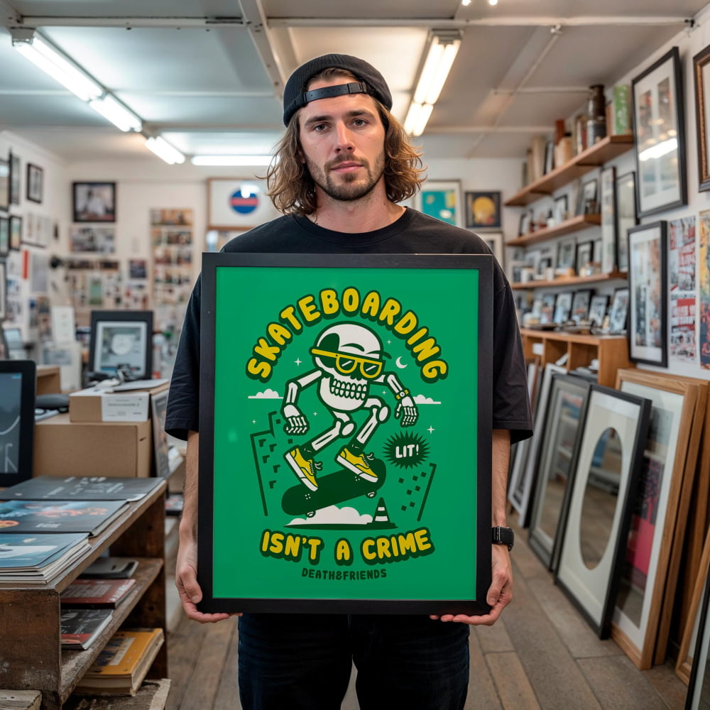 A man is holding a framed poster with a cartoon skeleton skateboarding and the text "Skateboarding isn't a crime" in a room filled with various items.
