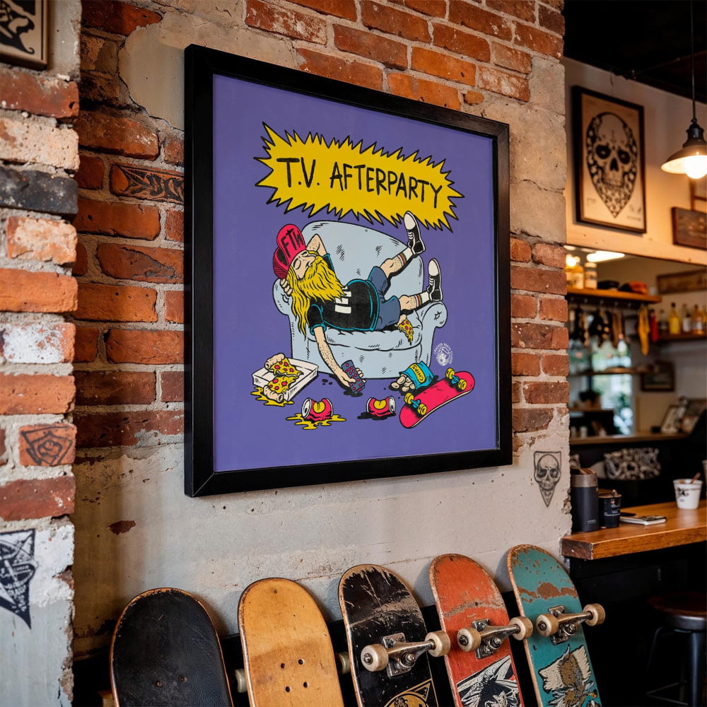 a framed cartoon-style illustration of a person lying on a couch with a skateboard, surrounded by various skateboards.