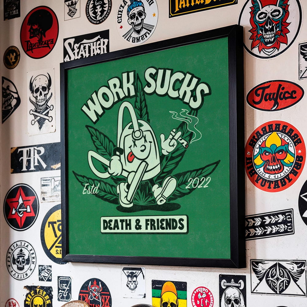 a wall adorned with a variety of stickers and decals, including a prominent green poster with the text "WORK SUCKS" and "DEATH & FRIENDS" displayed prominently.