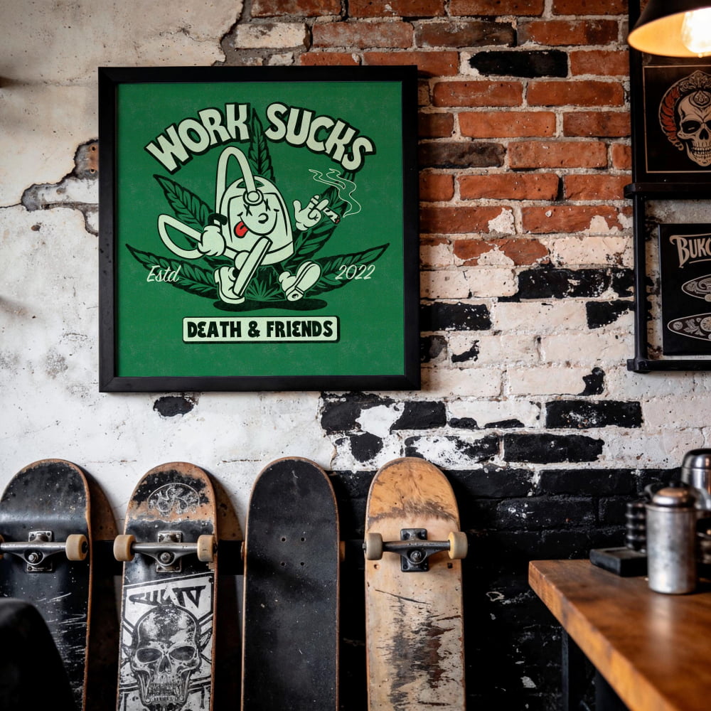 a framed poster with a cartoon character and text, hanging on a brick wall. Below the poster, there are several skateboards lined up against the wall.